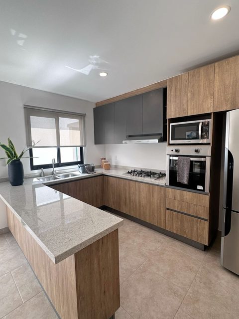 Cocina en U de madera con columna de hornos