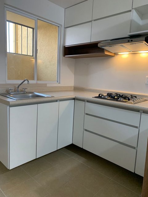 Cocina en L blanca con estante de madera